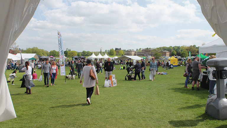 A view tents and visitors milling on green grass at Derbyshire Food and Drink Festival