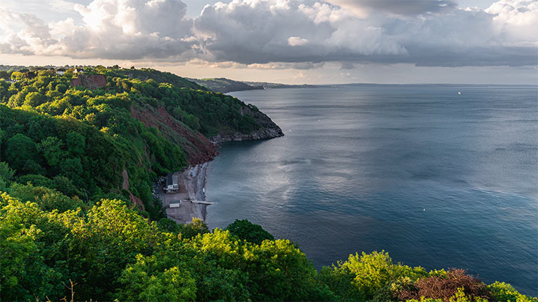 Overlooking Oddicombe Beach in Devon with a backdrop of greenery-clad cliffs