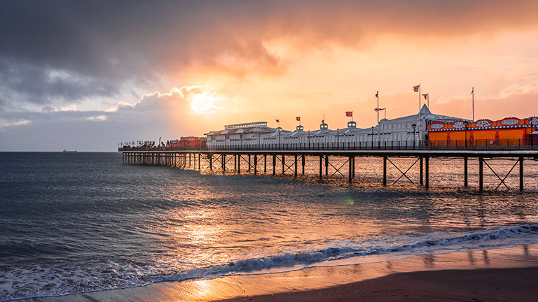 Paignton Sands pier in Devon at sunset