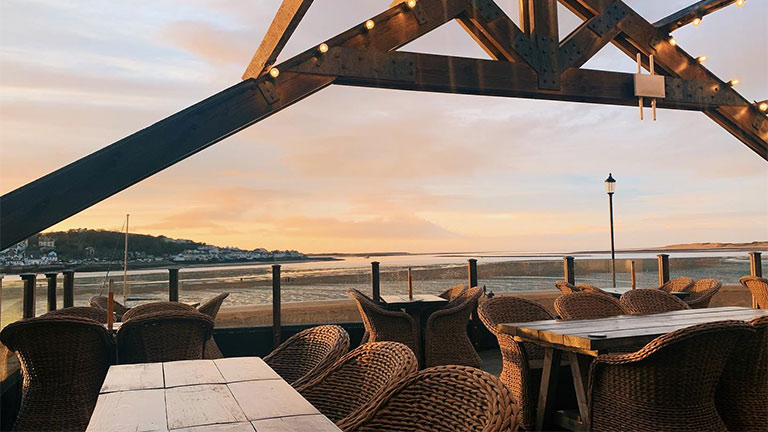 The sun-kissed terrace of The Boathouse in Instow overlooking the water