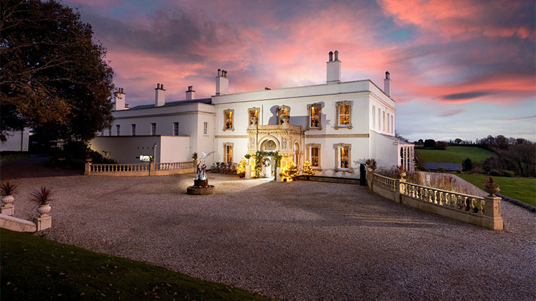 The stunning Georgian facade of Michael Caines' Lympstone Manor at sunset