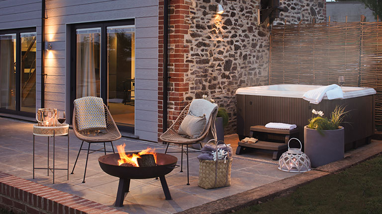 The terrace of Acacia in Crediton, designed with an outdoor table and chairs and alfresco hot tub
