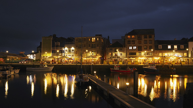 The illumination waterfront of The Barbican in Plymouth at nighttime