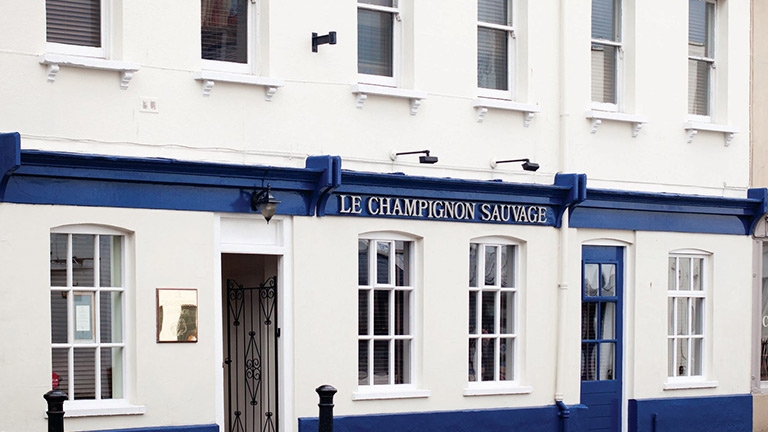 The white and blue facade of Le Champignon Sauvage in Cheltenham