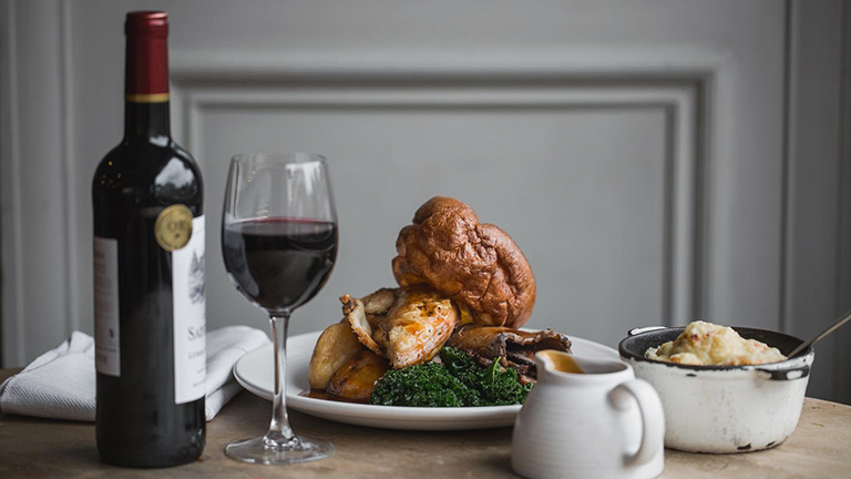 A delicious Sunday roast served with a glass of red wine at The Wheatsheaf Inn in Northleach