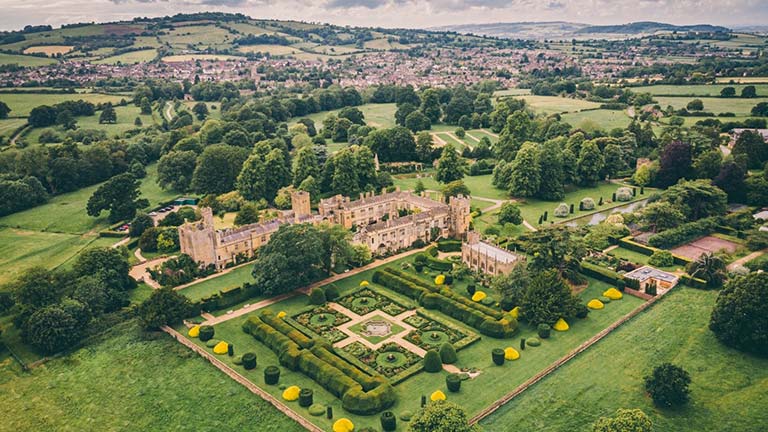 An aerial view of Sudeley Castle, its manicured gardens and surrounding landscapes in Gloucestershire