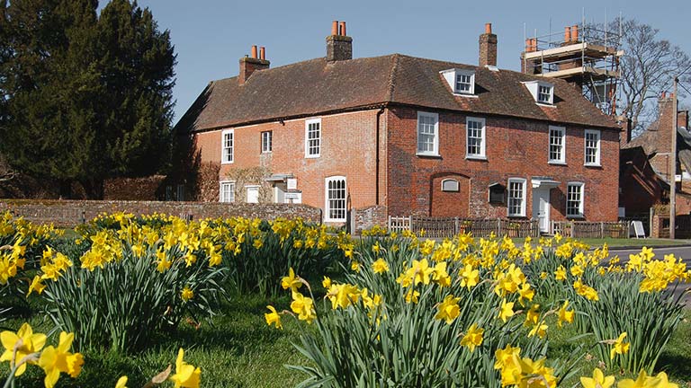 A view of Jane Austen's House in Chawton with pretty daffodils in the foreground