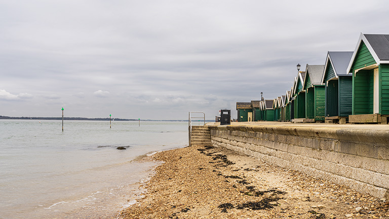 Beach huts overlooking the shore of Gurnard Beach