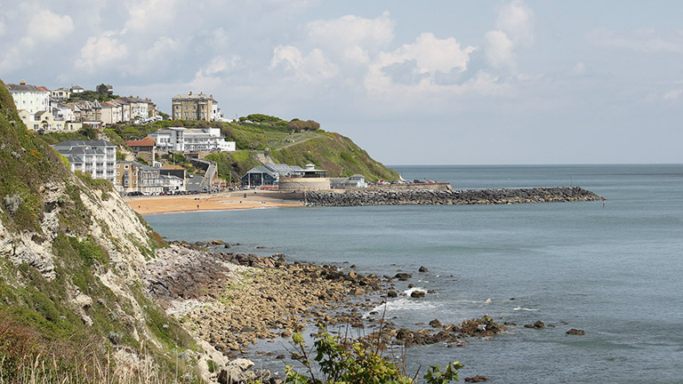 A distant view of Ventnor Beach over the sea on the Isle of Wight