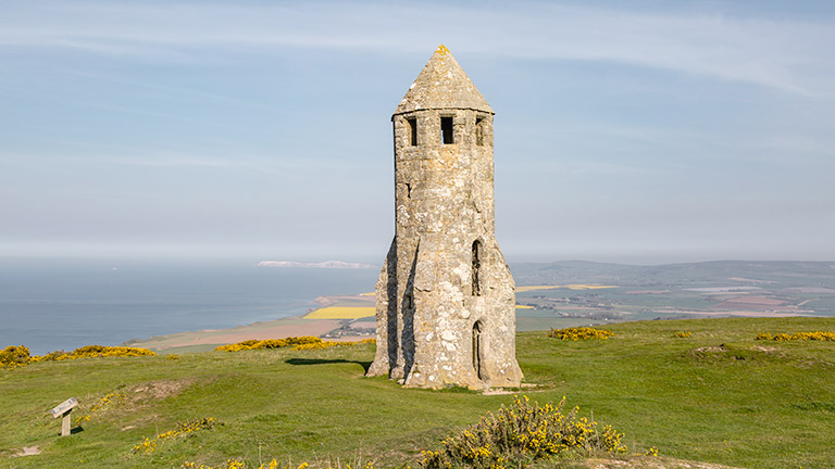 St Catherine's Oratory atop St Catherine's Hill with sea views in the background