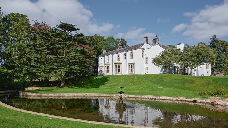 Farlham Hall, home of The Cedar Tree, surrounded by manicured grounds in Cumbria