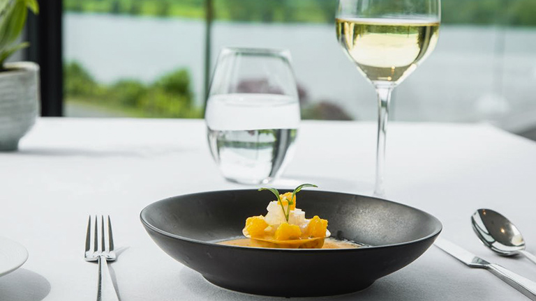 A refined dish served with a glass of white wine in The Samling restaurant, Windermere