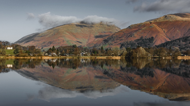 Crisp reflections in the glassy water of Grasmere Lake