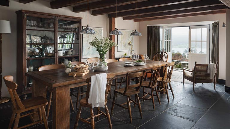 A big wooden dining table and island counter in the open plan kitchen at Outrake Farm in the Lake District