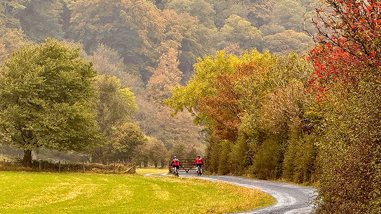 Cyclists riding through autumn Lakeland scenery