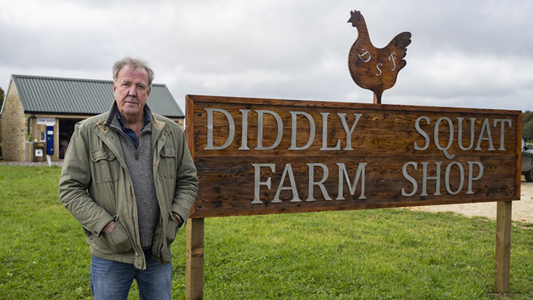 Jeremy Clarkson stood next to the Diddly Squat Farm Shop sign in Chadlington