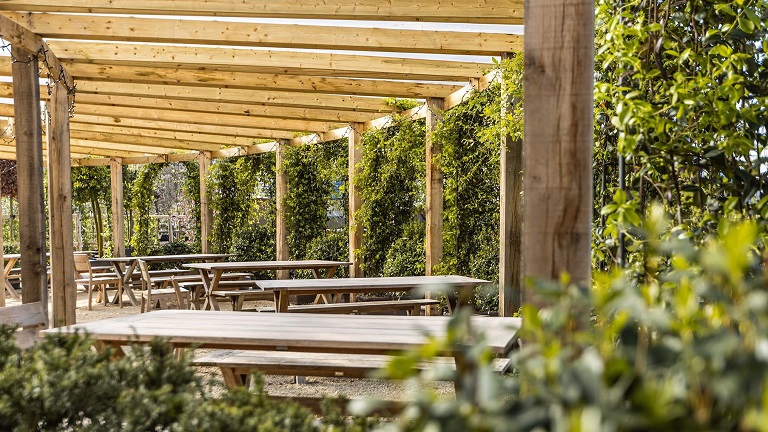 The outside seating area with wooden bunches and pretty foliage at the Yurt at Nicholsons in Oxfordshire