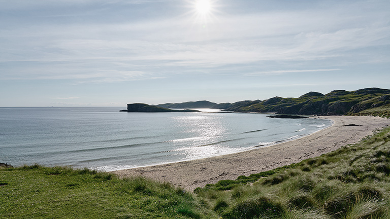 The sandy arc of Oldmore Beach in Scotland