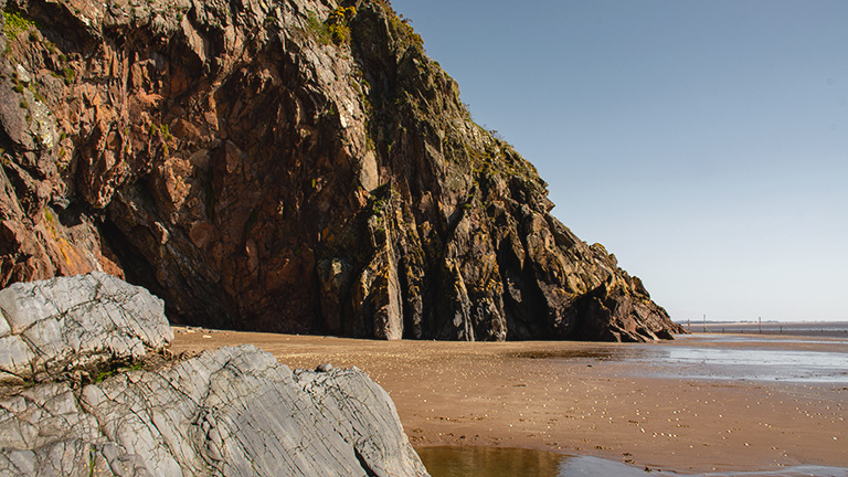 The sandy shores and cliffs of Sandyhills Beach 