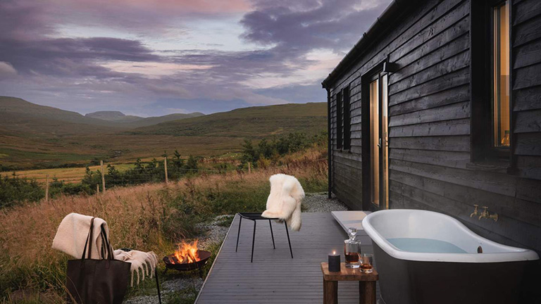 The outdoor bathtub and deck of Black Box Cabin in Skye with mountain views