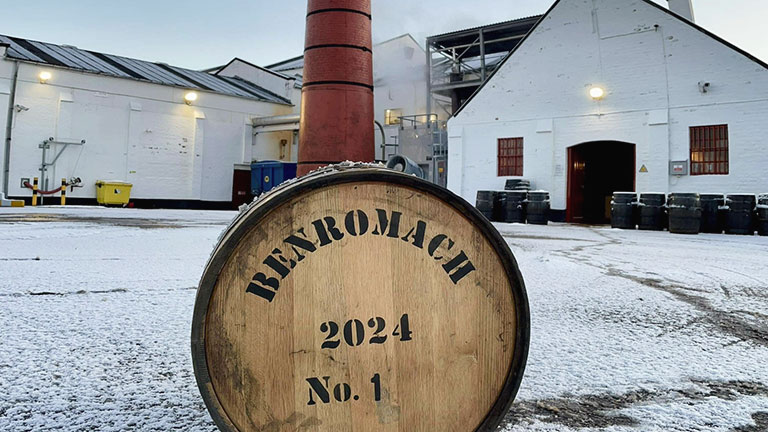 A whisky barrel on snowy ground outside of Benromach Distillery