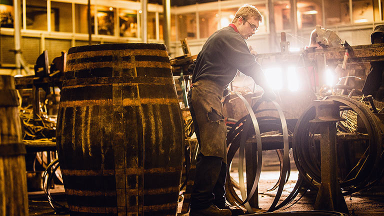 Coopers working on a large oak barrel at Speyside Cooperage