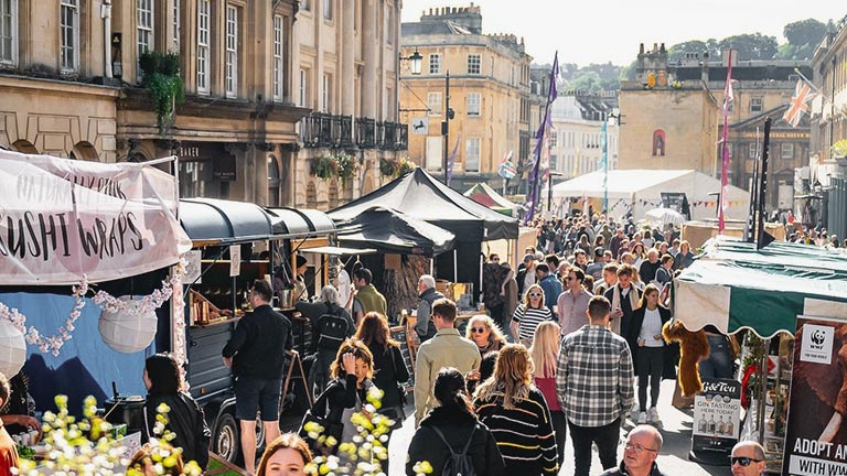 People browsing food stalls in the sunshine at the Great Bath Feast