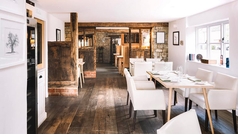 The bright interiors of The Royal Oak in Warwickshire with tables and chairs in the sunlight