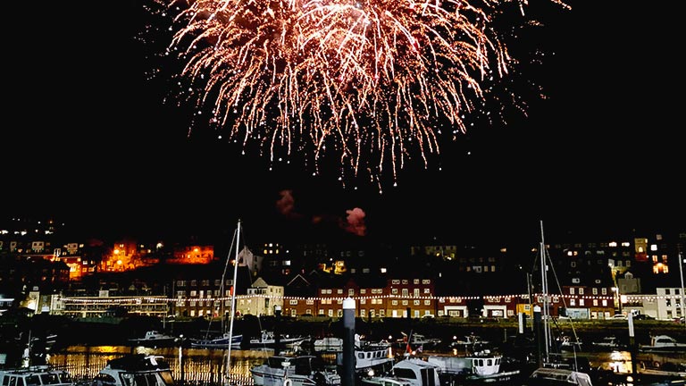 Fireworks bursting in the sky above Whitby harbour 